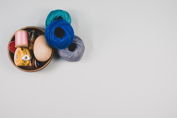 Poster - Closeup shot of colored cotton threads and sewing materials on a white background