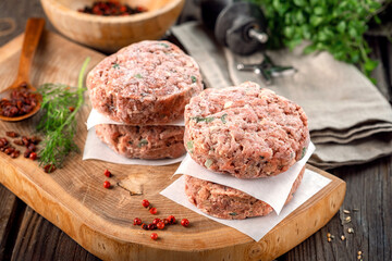 Wall Mural - Frozen spicy pork patties with seasonings on table. Butcher minced meat cutlet