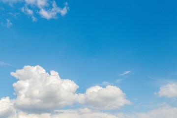 Wall Mural - White fluffy clouds in a clear light blue sky