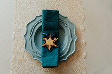 Wooden Wnowflake Napkin Ring With Teal Napkin And Turquoise Plates
