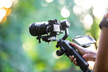 An Unidentified Woman Using Gimbal Stabilized Mirrorless Camera To Record Footage.