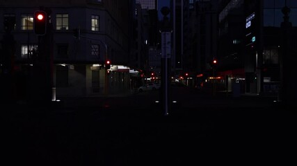 Sticker - Downtown city street background in dark of night with street and passing cars lighting against dark background.