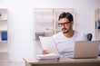 © Elnur - Young male student employee at workplace