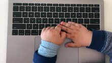 Top Down View Of Toddler's Hands On Laptop's Keyboard