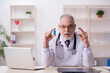 © Elnur - Old male doctor working in the clinic
