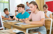 © JackF - Group of modern teenagers sitting with mobile phones on lesson in classroom