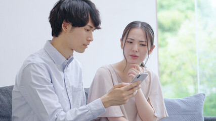 Poster - スマホを見る若い夫婦・カップル