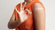 © Orathai - Asian woman shows plaster on her shoulder after being vaccinated against Covid-19. Coronavirus vaccination campaign concept