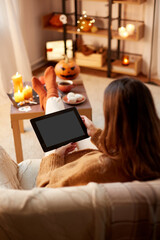 Wall Mural - halloween, holidays and leisure concept - young woman with tablet pc computer at home