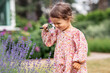 © Syda Productions - childhood, leisure and people concept - happy little baby girl with magnifier looking at lavender flowers in summer garden