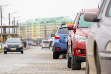 Canvas Print - Cars parked in a row on a city street side.