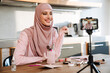 © Drobot Dean - Muslim woman taking footage on cellphone while showing beauty product