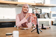 © Drobot Dean - Muslim woman taking footage on cellphone while showing beauty product
