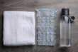 Bottle of water, ice pack and towel on wooden background, flat lay. Heat stroke treatment