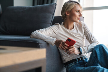 Canvas Print - Smiling mid aged blonde woman using mobile phone