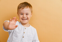 White Boy With Down Syndrome Smiling And Gesturing At Camera