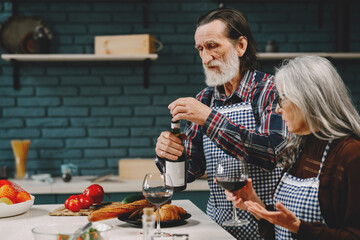 Wall Mural - Modern senior drinking wine together in kitchen