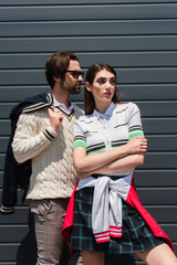 Sticker - young couple in fashionable clothes looking away while posing outdoors