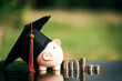 piggy bank With Graduation Cap on black glass floor,Money saving concept..