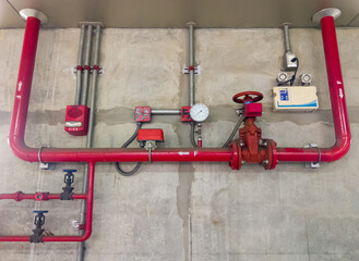 The red metal pipe and large valve of the fire fighting system