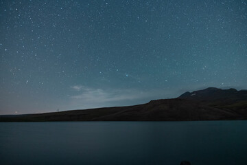 Wall Mural - beautiful night landscape, starry sky, lake and mountains silhouette.