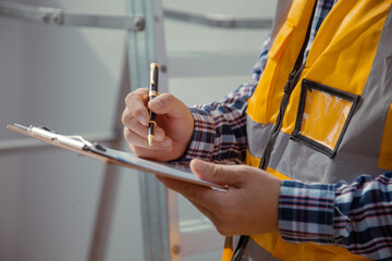 building contractor Check and write down the details of the construction. wearing yellow construction clothes house construction contractor concept