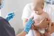 © Angelov - The doctor makes a baby vaccination on a white background.