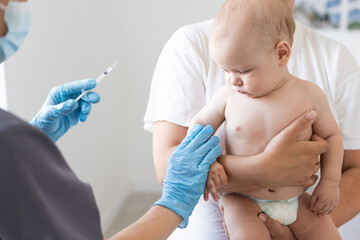 the doctor makes a baby vaccination on a white background.