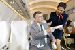 flight attendant checking passenger ticket in airplane