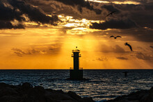 Silhouette Of A Lighthouse In The Sea On The Sunset