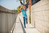 Fototapeta Miasto - Excited energetic boy child scream running on summer promenade, excitement