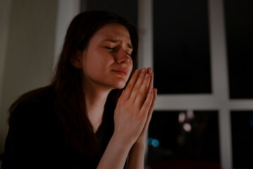 Canvas Print - Young woman praying and crying at night