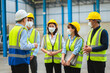 © SEVENNINE_79 - The factory employee consists of engineers, foreman, technicians, and related department staff. Wear a mask, hard hat, and vest. meeting before starting work inside the warehouse. Teamwork concept.