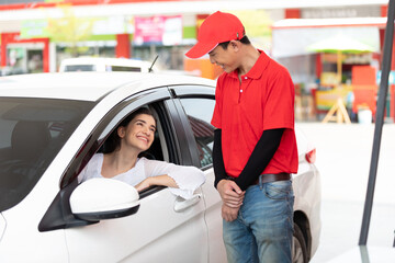 Wall Mural - young woman in the car, talking to worker for refueling gasoline at the gas station