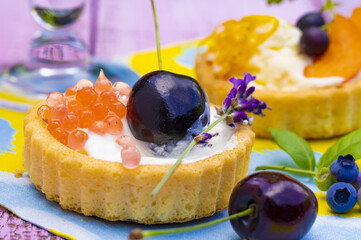 Two creamy cookies with fruits on a colorful napkin