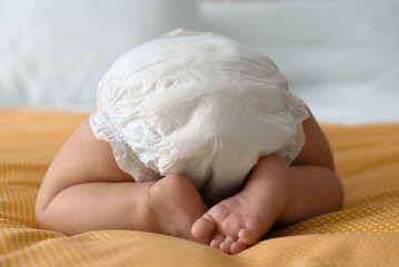 Sticker - Cute little baby in diaper on yellow blanket