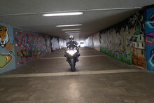 Motorradfahrer In Bunten Graffiti Tunnel 