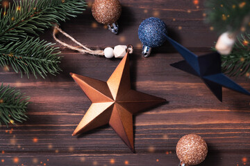 Wall Mural - Festive card with Christmas composition with brown and blue stars on wooden brown background.