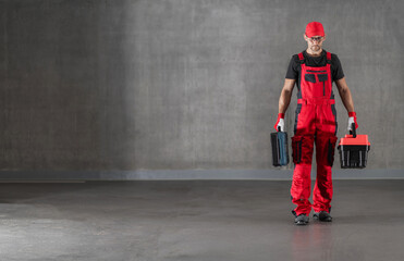 Wall Mural - Construction Worker in Red Uniform Walking with Toolboxes in His Hands