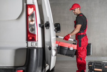 contractor worker loading his tool boxes to his commercial van