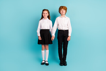 Poster - Photo of two positive friendly schoolkids hold hands wear white shirt uniform isolated blue color background