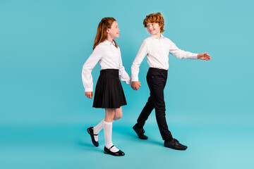 Full length body size profile side view of two attractive cheerful kids going to college isolated over bright blue color background