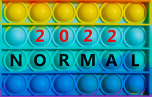 Symbol Of Covid-19 Normal In 2022. Words 'Normal 2022' On Rainbow Pop It. Beautiful Background, Copy Space. Medical, Covid-19 Normal In 2022 Concept.