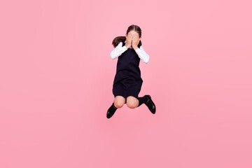 Canvas Print - Full length body size photo schoolgirl jumping up covering face with hands isolated pastel pink color background