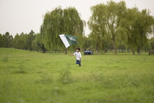 Cheerful Active Little Boy Celebrating 14th Of August, Pakistan Independence Day With Waving Pakistani Flag. F-9 Park Islamabad, Pakistan.