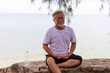 © sutthichai - Senior male meditation outdoor.