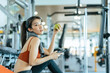 © Charnchai saeheng - Woman exercise in gym fitness breaking and relax. hand  holding apple fruit after training sport and dumbbell, water bottle on the ground.