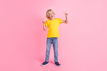 Full size photo of young small boy happy positive smile show fingers cool peace v-sign isolated over pink color background