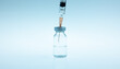 Coronavirus vaccine and syringe with needle on blue background