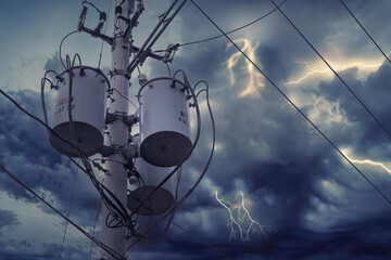 Three single-phase pole-mounted distribution transformers. During an overcast sky or before a storm.